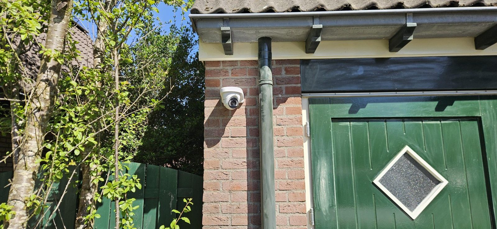 Witte camera boven de garagedeur van een woonhuis
