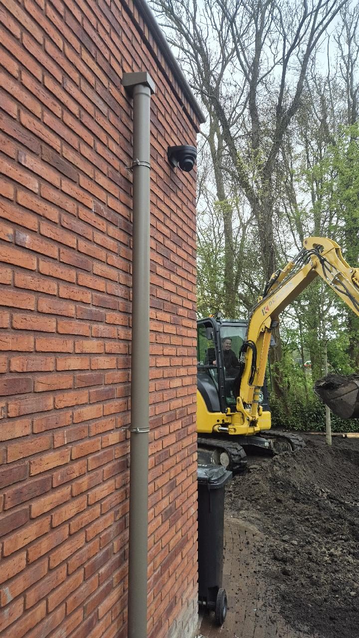 Zwarte dome-camera op de hoek van een woning in aanbouw