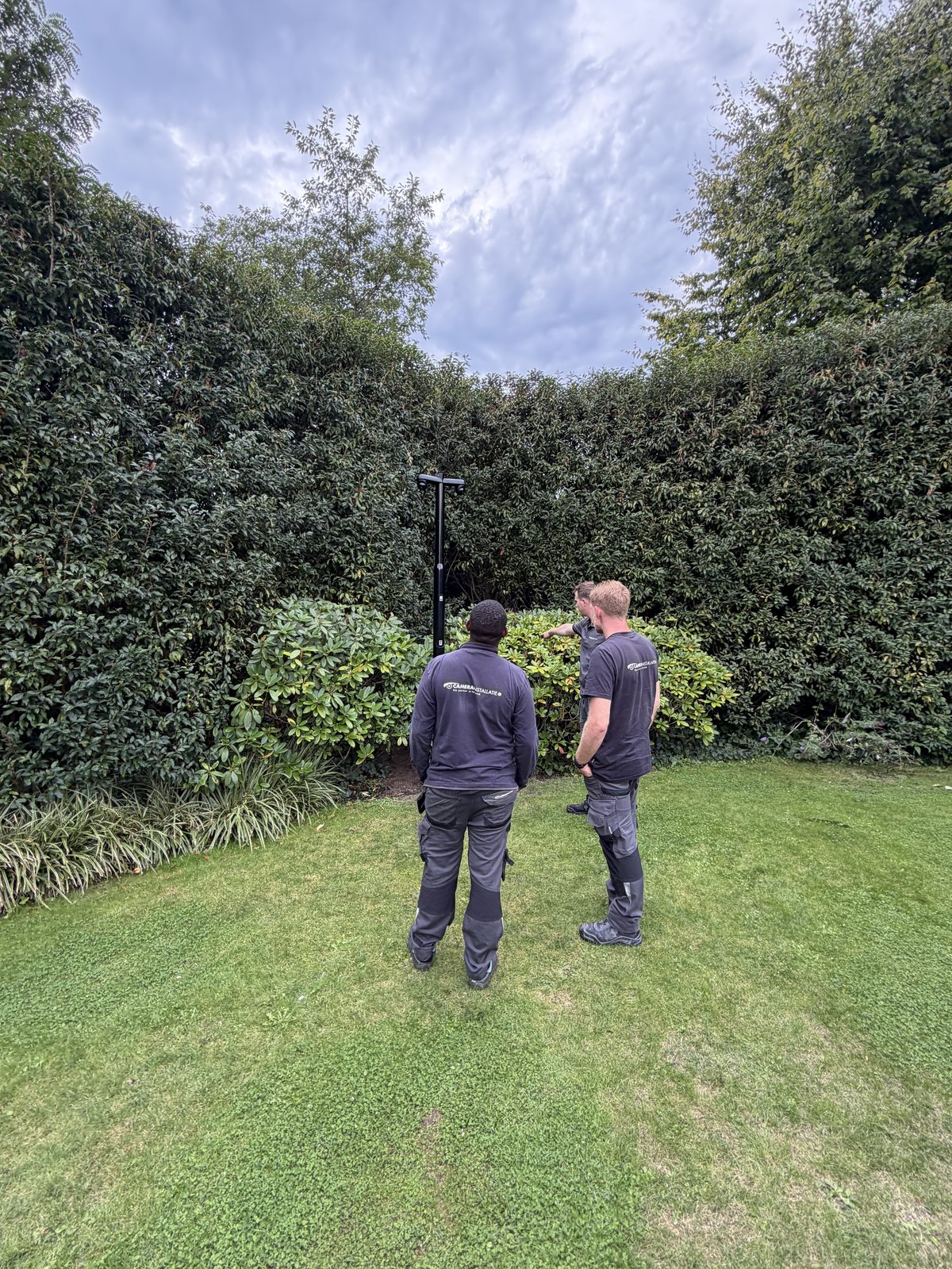 Twee monteurs overleggen in een tuin