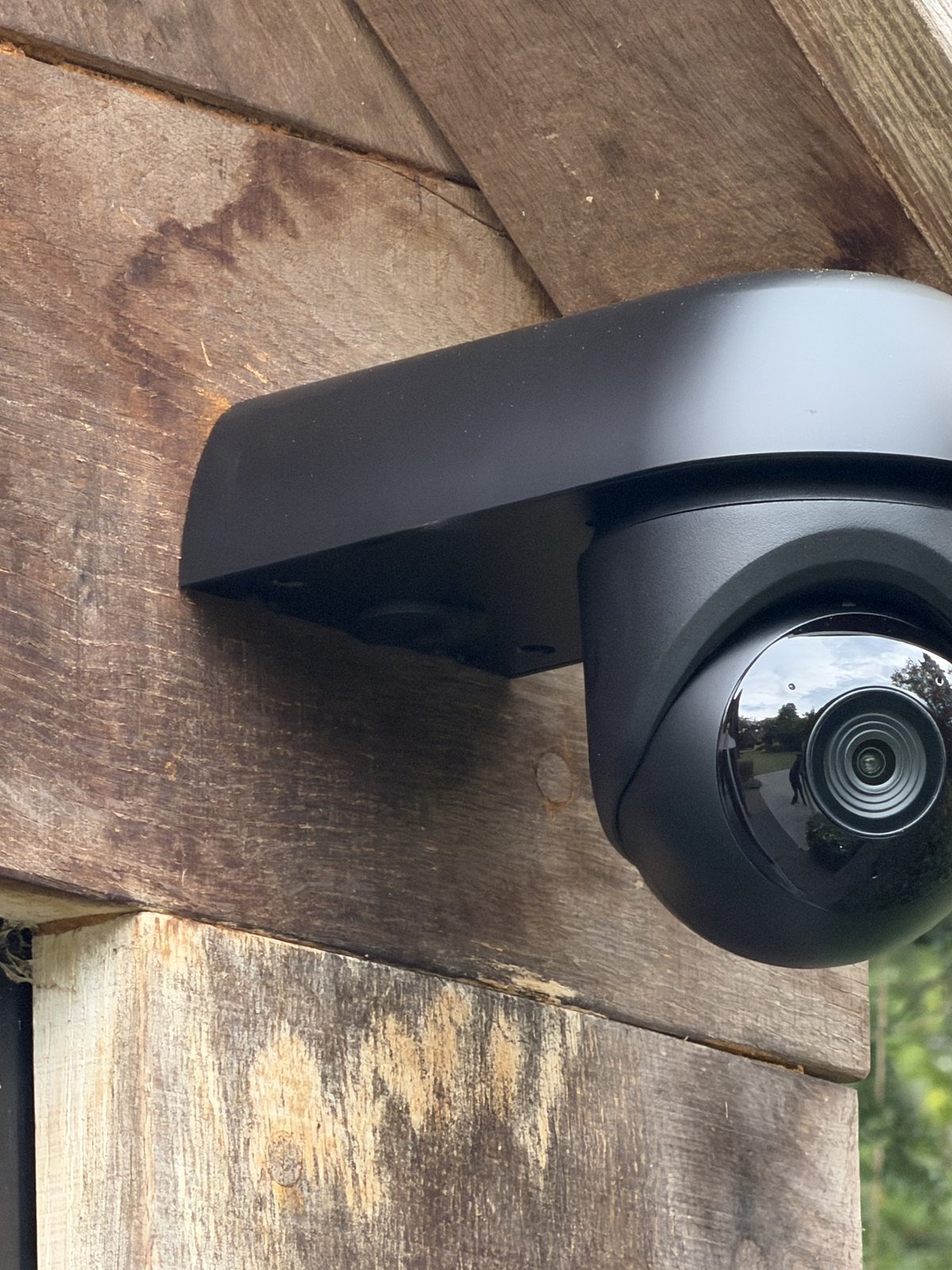 Draaibare camera onder een houten overstek van een bijgebouw
