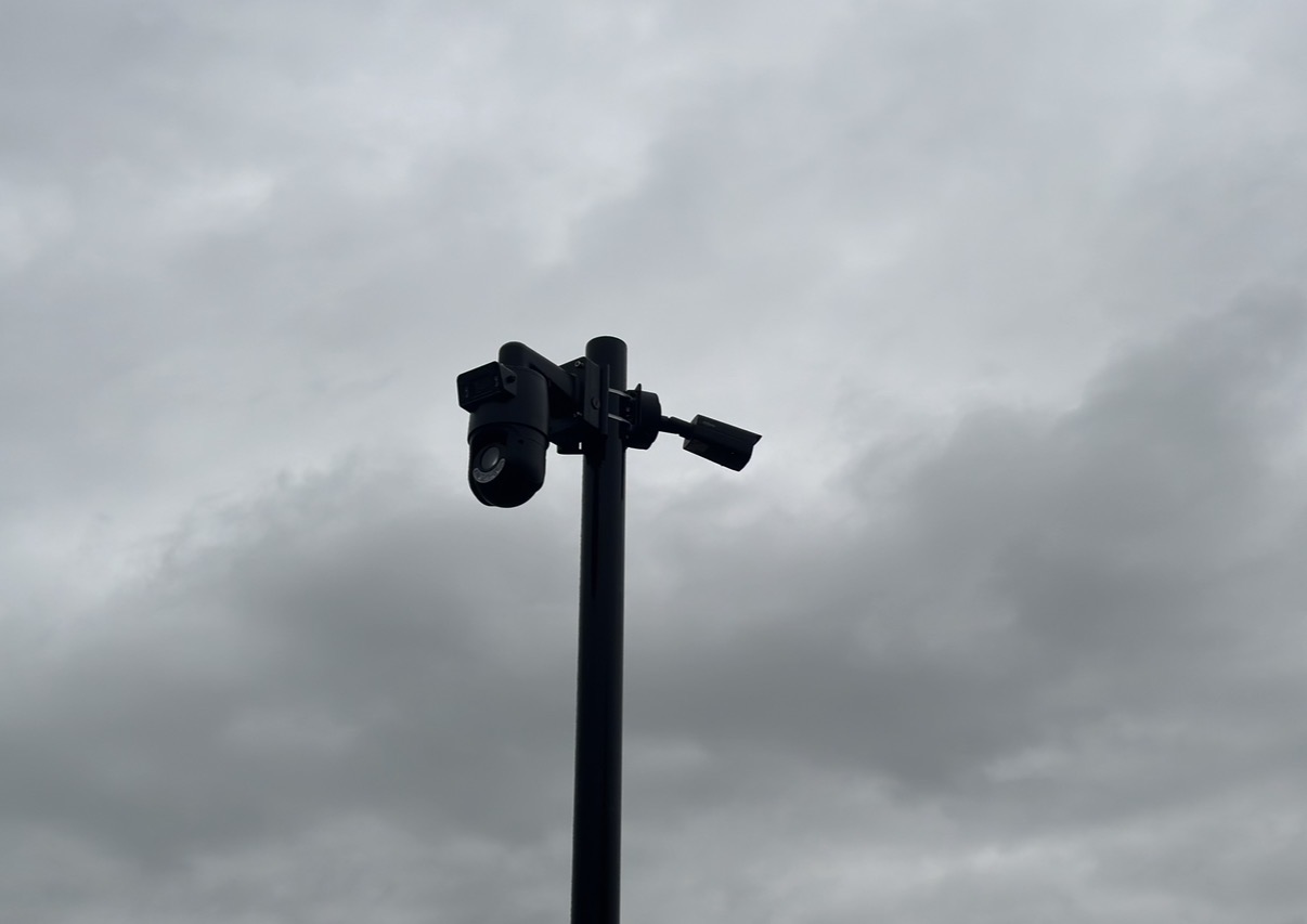 Buitencamera op een paal tegen een bewolkte lucht