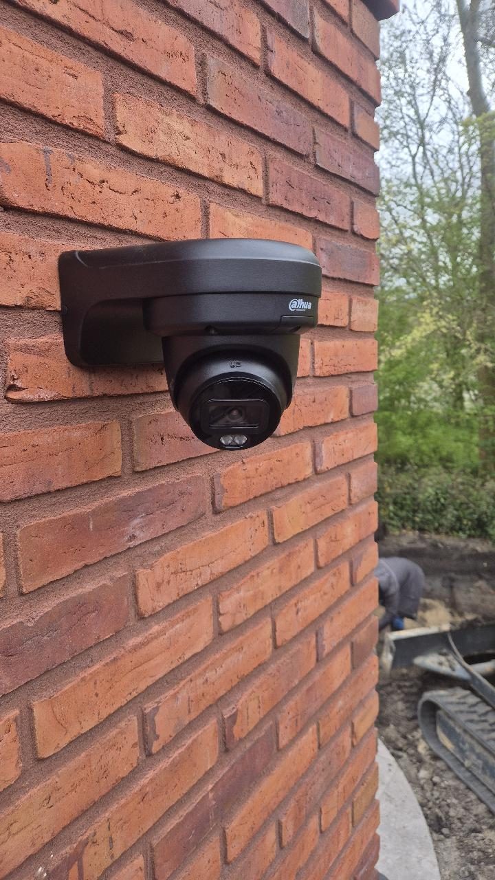 Zwarte dome-camera op baksteen
