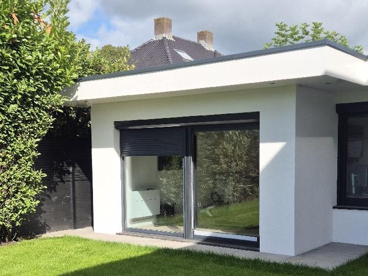 Aanbouw met schuifpui aan de tuinkant van een woning