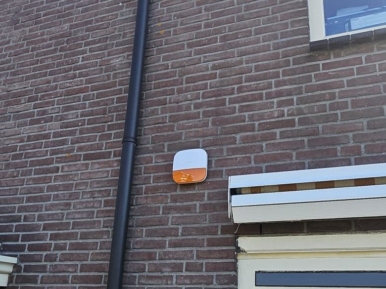 Buitensirene met flitser aan een bakstenen gevel