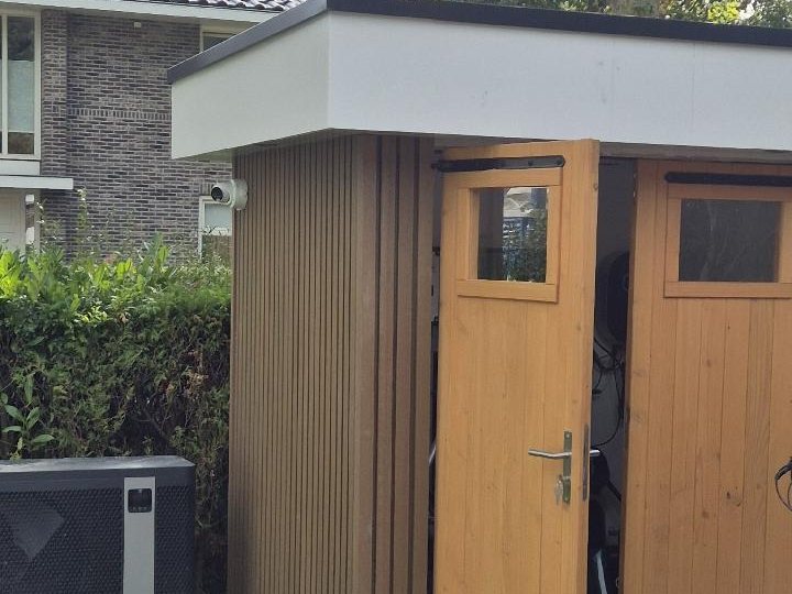 Camera aan de gevel van een houten berging in de achtertuin