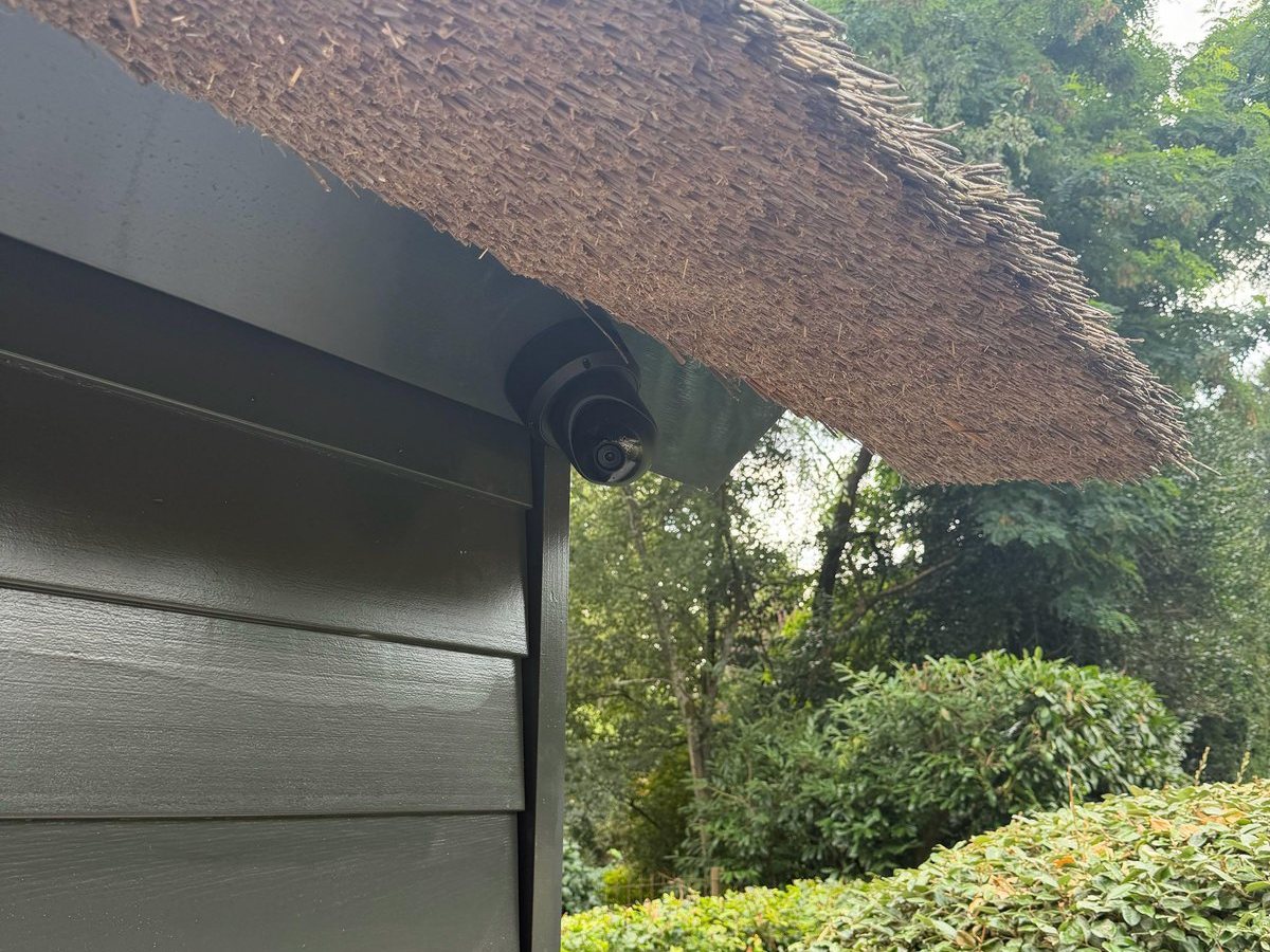 Camera onder de rieten dakrand van een bijgebouw in de tuin
