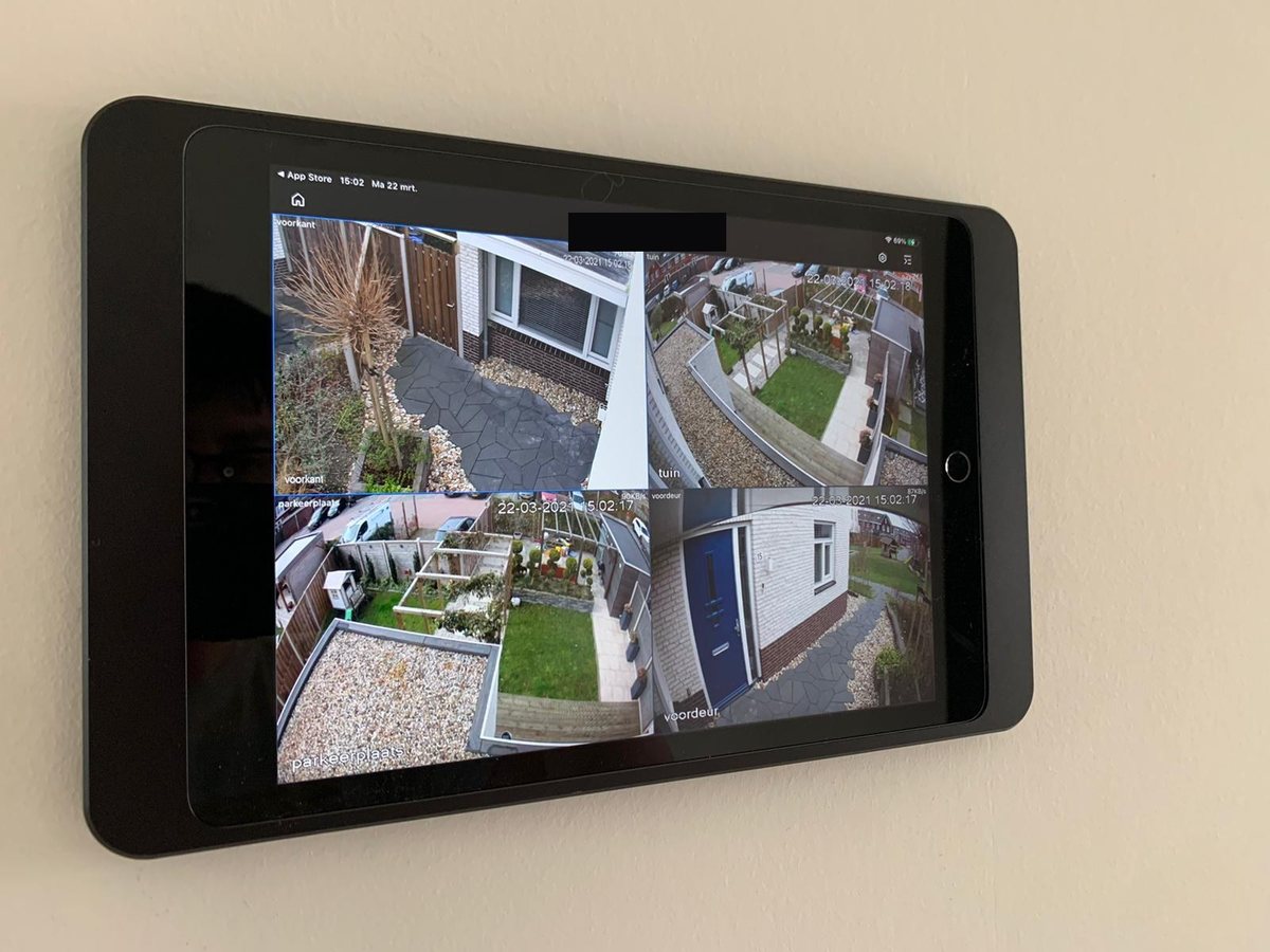 Tablet aan de wand met vier camerabeelden van rondom het huis