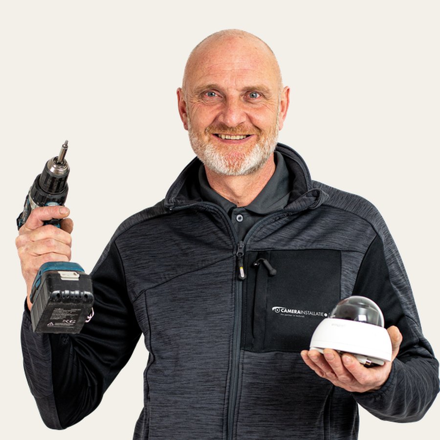 Richard, monteur bij CameraInstallatie, met boormachine en koepelcamera