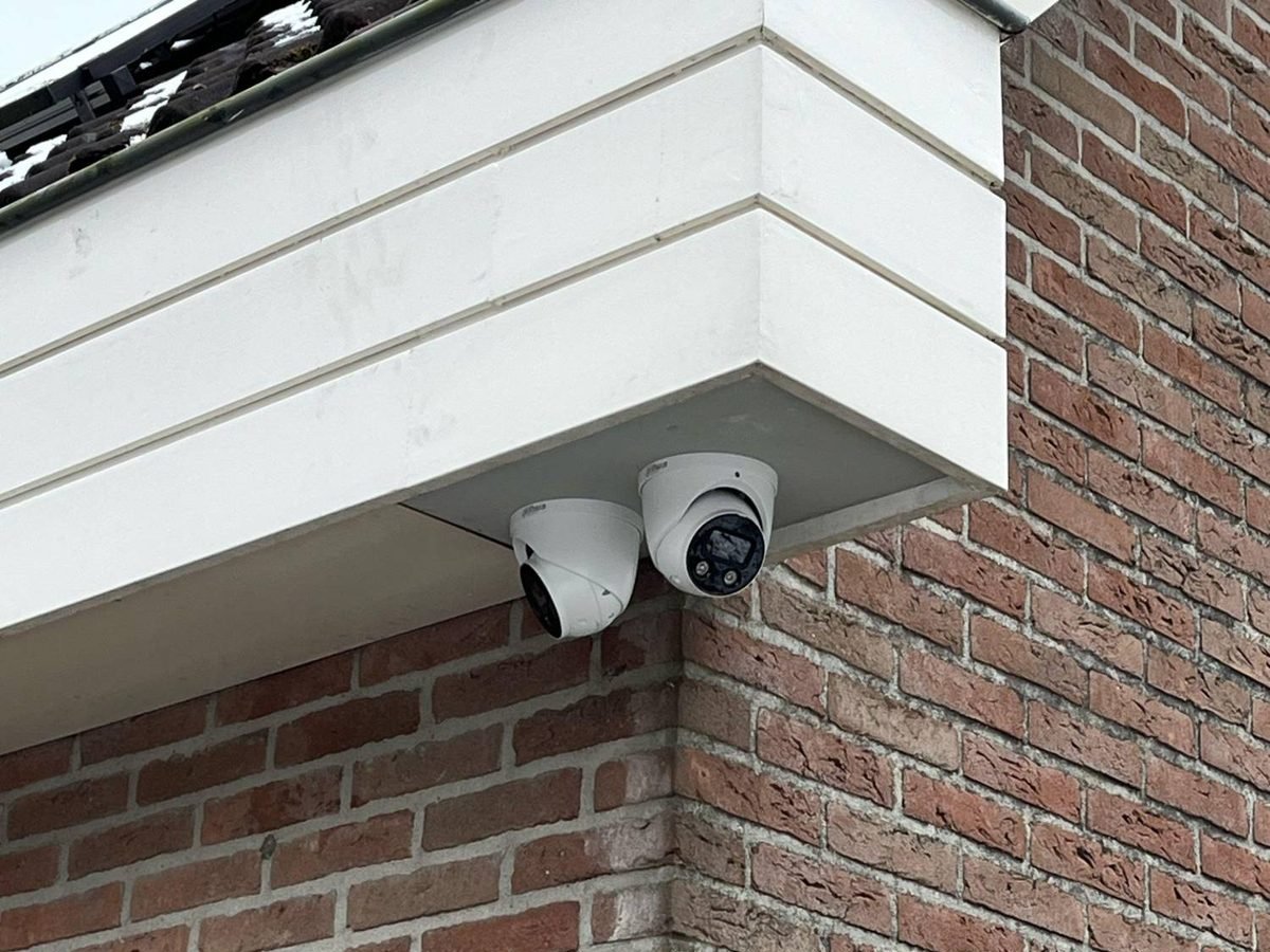 Twee camera&rsquo;s netjes onder de overstek van een woning gemonteerd