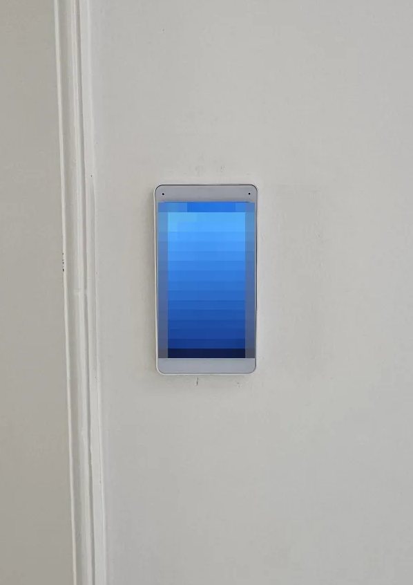 Wit binnenscherm van de intercom aan de wand in de hal, naast een oude houten deurlijst