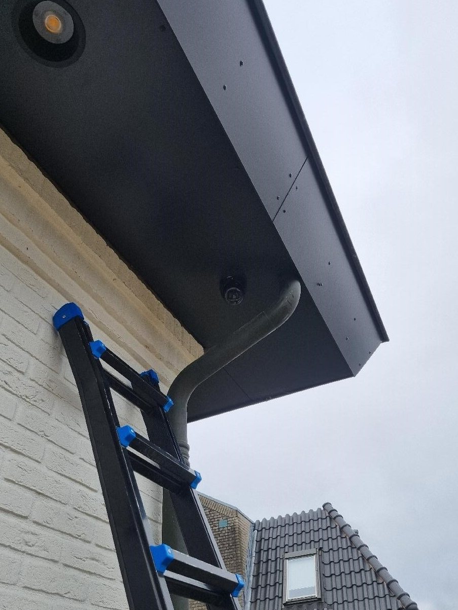 Zwarte camera in de dakrand van onderaf gezien, zonder zichtbare kabel
