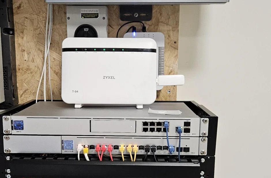 Netwerkkast in de kelder met router, switch en gekleurde patchkabels